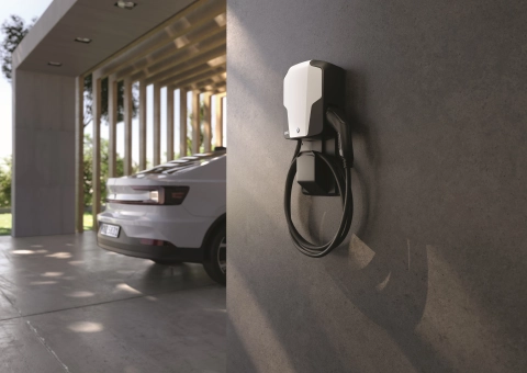 Wallbox mit Elektroauto im Hintergrund